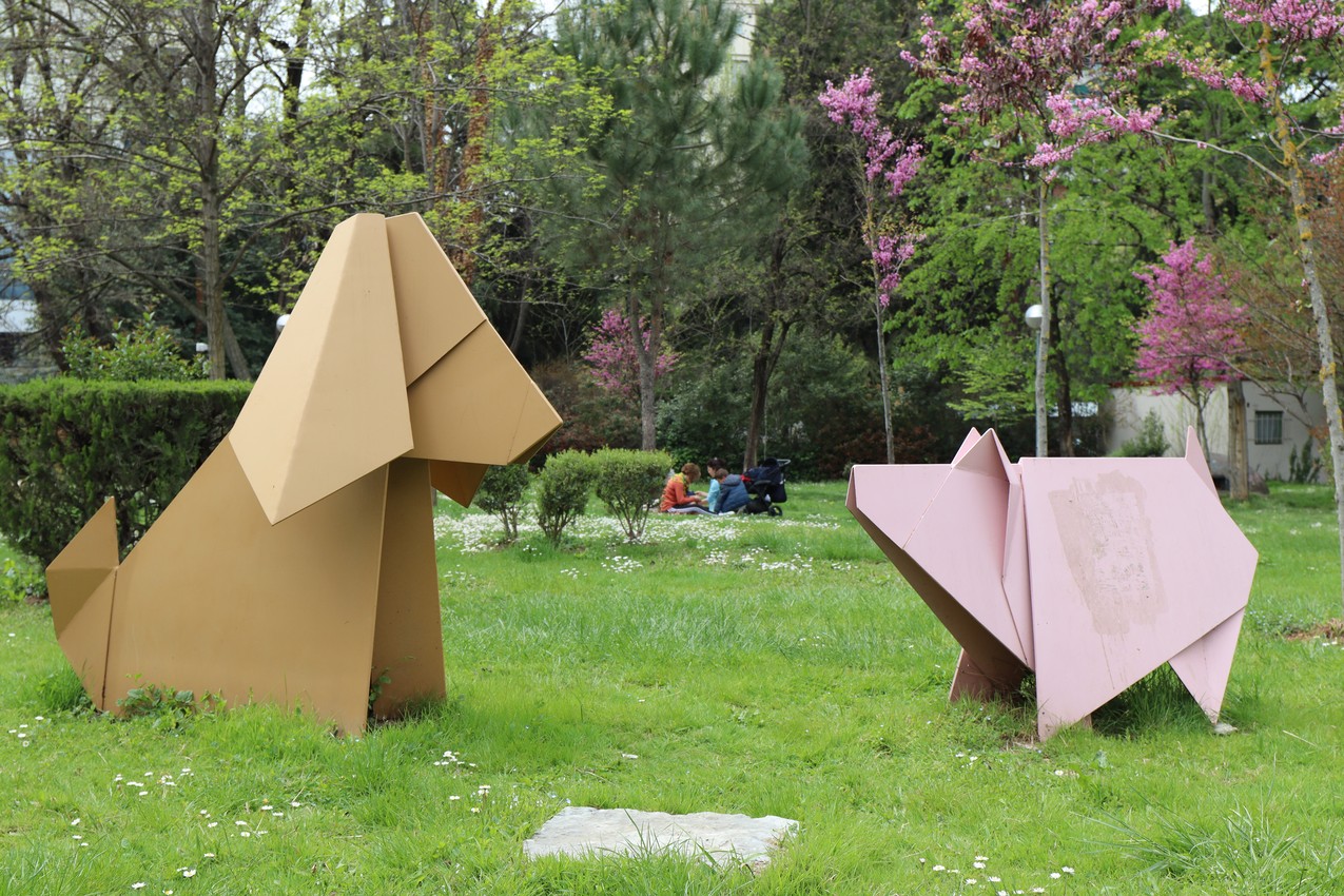 An abstract statue of a dog and a pig in a park, Tirana